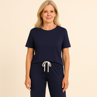 Woman wearing a navy blue outfit with white drawstring on a beige background